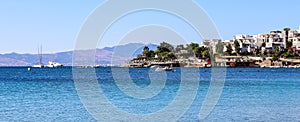 Blue sea, boats, mountains and small town on the coast of the Aegean sea. Summer holidays concept