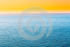 Blue Sea Or Ocean And Yellow Clear Sunset Or Sunrise Sky Background