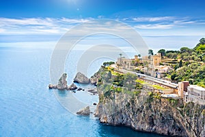 Blue sea and rocky coast at Cape Taormina. Taormina located in Metropolitan City of Messina, on east coast of island of Sicily,