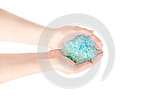 Blue sea salt for a bath in the hands of a girl isolated on white background