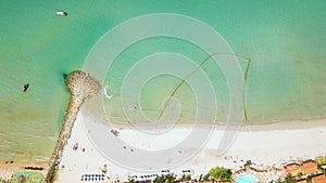 Blue sea and sandy beach on tropical island with resort hotel and swimming pool. Aerial landscape. Sea boats sailing