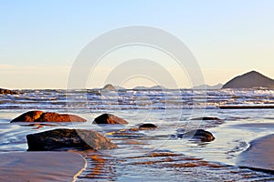 Paradise tropical. Blue sea with small white waves. In the background, the sky was clear. In front of small stones in the water. R