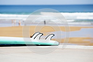 The blue of the sea with a surfboard in the foreground on the sandy beach. relaxing outdoor vacations with paradisiacal views on