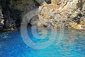 blue sea water  rocks  a cave carved in the rock  a cave in the rocks by the sea  a blue cave in Sicily  Italy