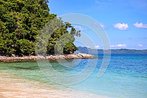 Blue sea water and white beach on sunny day. Tropical island paradise photo. Green forest jungle near seashore
