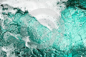 Blue sea water white foam texture background closeup, foamy ocean wave pattern, aqua bubbles surface, swimming pool backdrop