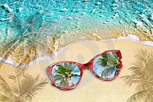 Blue sea wave, yellow sand beach, turquoise ocean water, red sunglasses, reflection blue sky, green palm trees, summer holidays