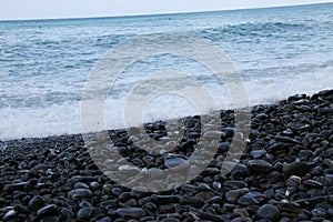 Blue sea waves on the black beach