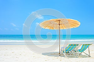 Blue sea and white sand beach with beach chairs and parasol