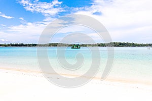 Blue sea and white sand with blue sky and single boat in thailan