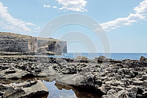 Blue seascape with cliff at limestone coastline in malta