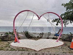 The blue seaside, the deactivated heart-shaped swing