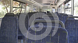 Blue seats inside of empty city bus.