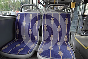 Blue seats inside of empty city bus.