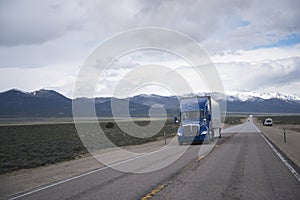 Blue semi truck on straight road on Nevada plateau