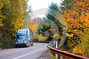 Blue semi truck on winding highway in autumn Columbia Gorge