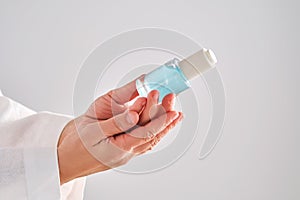 Blue serum with pipette in a womans hands in a robe.