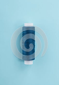 Blue sewing thread close-up with copy space. The thread is made of cotton and synthetics for the production of clothing