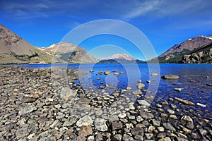 The blue shallow lake with a stony beach photo