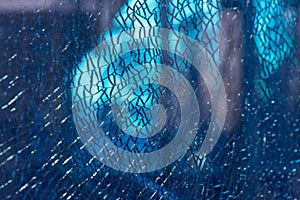 Blue shattered glass completely covered with cracks, creating a fragmented, textured surface with sharp patterns and a dramatic