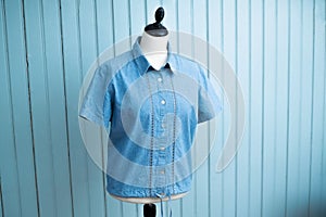 A blue shirt is displayed on a mannequin's torso photo