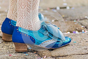 Blue shoes with decorations and lace stockings. Detail of a classic costume at the Carnival in Venice.