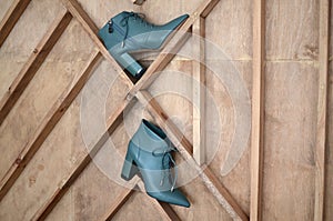 Blue shoes on a wooden brown background. Fashionable women`s blue boots. A pair of trendy warm boots