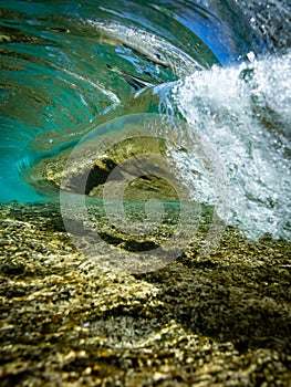 Blue shorebreak breaking from behind