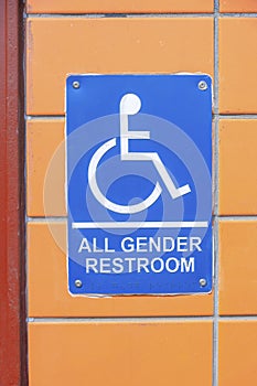 Blue sign with all gender restroom note and PWD symbol at San Francisco, California