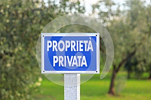 Blue sign with the inscription Private property in Italian outdoor in olive grove photo