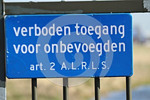 Blue sign for no trespassing at  entrance gate 45C at  the 06 Ã¢â‚¬â€œ 24 Kaagbaan at Amsterdam Schiphol Airport.