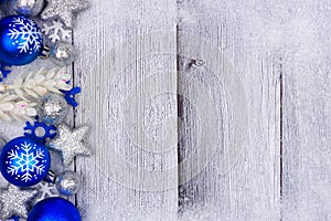 Blue and silver Christmas ornament side border on white wood