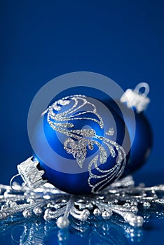 Blue and silver christmas ornaments on dark blue background