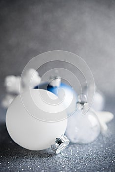 Blue, silver and white xmas ornaments on glitter holiday background. Merry christmas card.