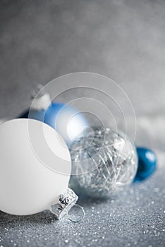 Blue, silver and white xmas ornaments on glitter holiday background. Merry christmas card.