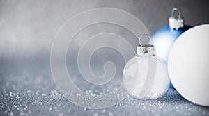 Blue, silver and white xmas ornaments on glitter holiday background. Merry christmas card.