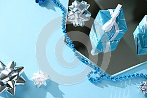 Blue and silver xmas ornaments on bright holiday background with space for text.