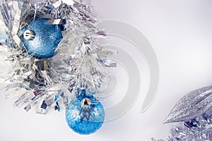 Blue and silver xmas ornaments on bright holiday background with space for text. Merry christmas