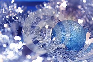 Blue and silver xmas ornaments on bright holiday background with space for text. Merry christmas.