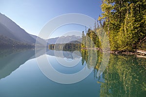 Blue skies, mountains and shoreline reflect perfectly, Birkenhead Lake Park near Pemberton and Whistler, Canada