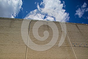 Blue skies over grey wall