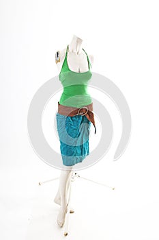 Blue skirt green top on mannequin full body shop display. Woman fashion styles, clothes on white studio background.