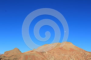 Blue sky above desert with moon