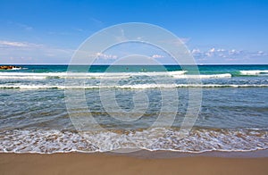 Blue sky, azure sea and thin strip of sand shot frontally