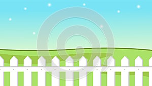 Blue sky background with decorative picket white fence and grass. Garden fencing, summer backyard