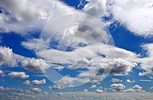 Blue sky background with fluffy and tiny clouds.