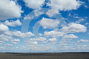 Blue sky background with soft silky clouds and field.