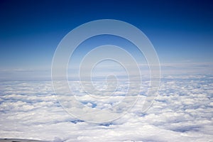 A view from the airplane, above white endless clouds, blue sky photo