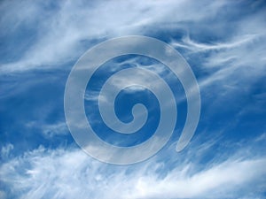 Blue sky background with wavy fleecy clouds