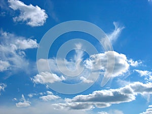 Blue sky background with wavy fleecy clouds